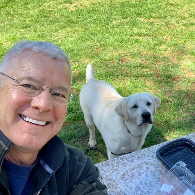 Dr. Stephen H. Pinkston outdoors with his dog